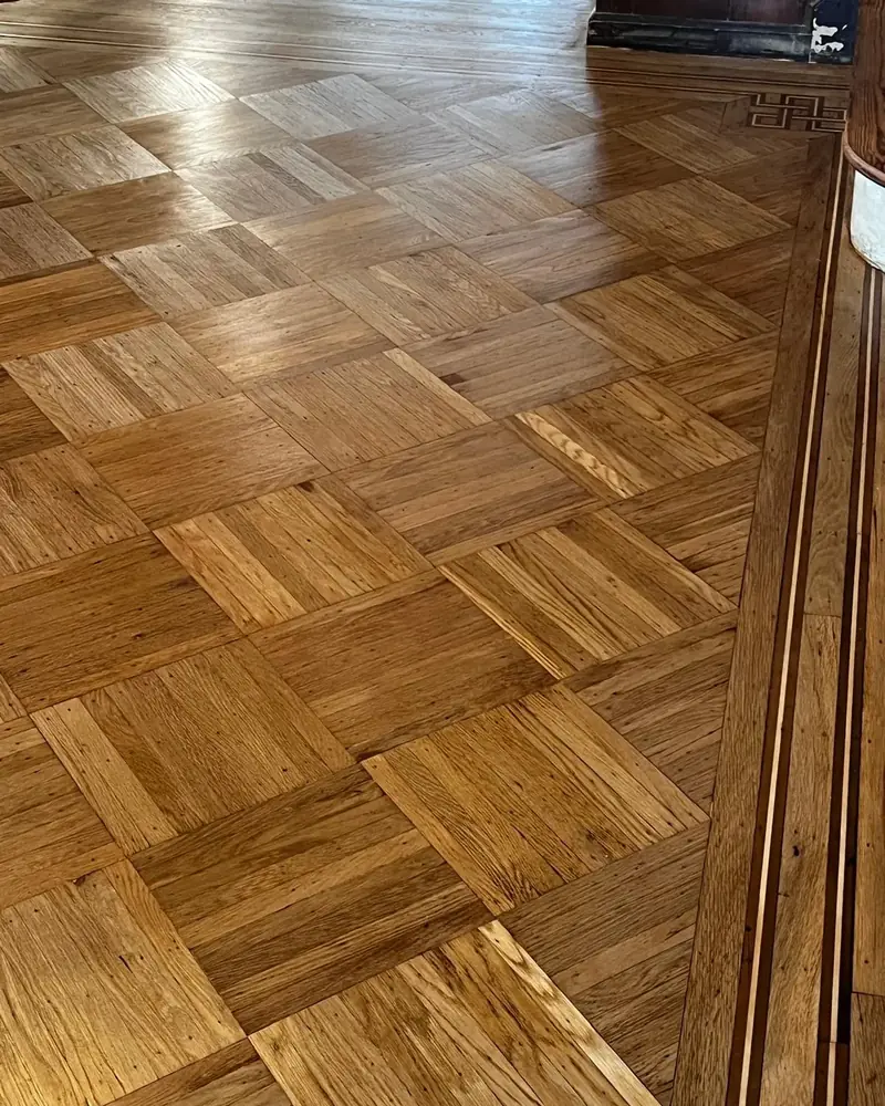 Oak parquet squares with an inlaid border and Greek key corner in a 1918 Sheepshead Bay house